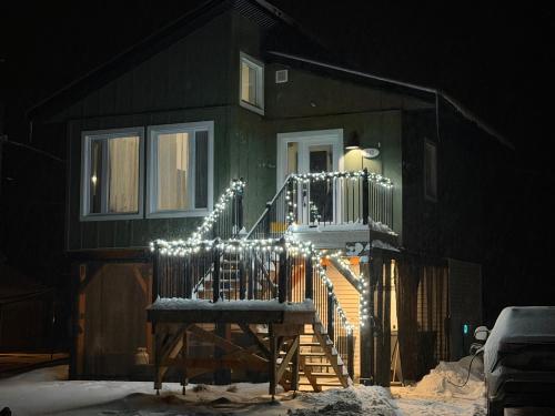 ein Haus mit einer Treppe mit Weihnachtsbeleuchtung in der Unterkunft Le Pignon Vert in Sainte-Séraphine