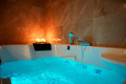 a bathroom with a tub and a sink and candles at Welcome to Hidden Spa in Wissous