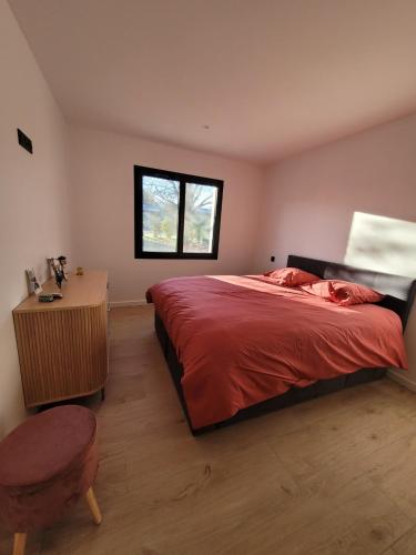 a bedroom with a bed and a table and a window at L'Etape de Charme in Bourdeaux