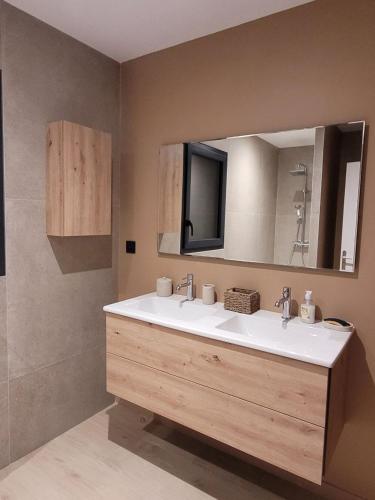 a bathroom with two sinks and a large mirror at L'Etape de Charme in Bourdeaux
