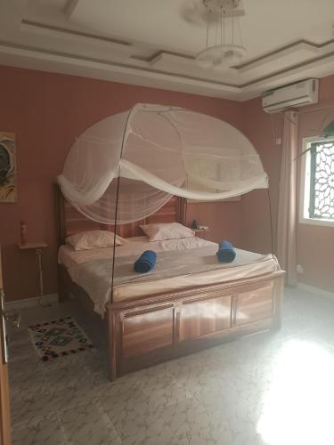 a bedroom with a large bed with a canopy at Villa Sara DIALLO in Ngaparou
