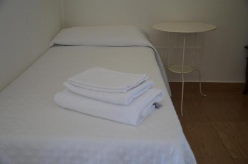 a bed with white towels stacked on top of it at B&B casa73 in Cicerale