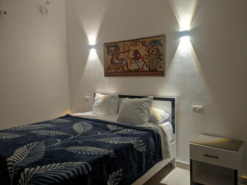 a bedroom with a bed and two lights on the wall at NOOR SEEN House in Luxor