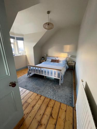 a bedroom with a bed and a wooden floor at Historic Highland Townhouse in Fort William