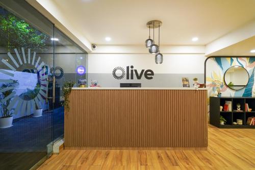 a store lobby with a large wooden reception desk at Olive Hotel Baner by Embassy Group in Pune