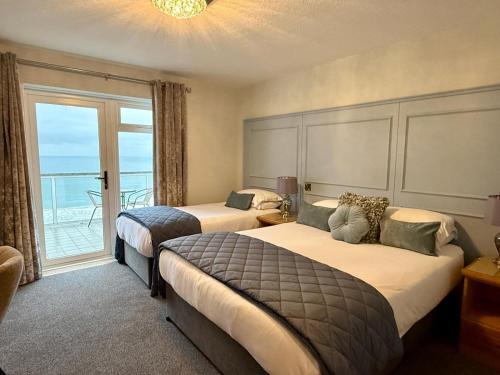 a hotel room with two beds and a balcony at Royal Court Hotel in Portrush