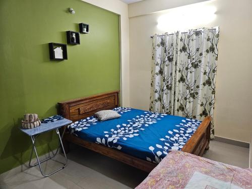 a bedroom with a bed and a table and a curtain at Rove Haven Condo in Bangalore