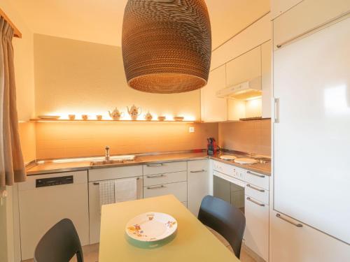 a kitchen with a dining table and a light fixture at Apartment Chesa Tscheppa 1 by Interhome in Sils Maria