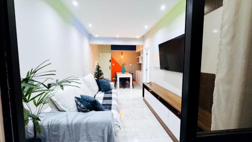 a living room with a couch and a flat screen tv at Apartamento Centro Ubatuba - Ubatuba House Temporada in Ubatuba