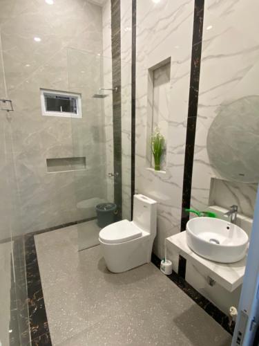 a white bathroom with a toilet and a sink at Laura villa in Cisarua