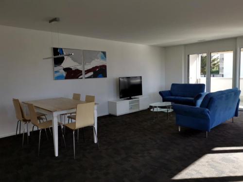 a living room with a table and a blue couch at Apartment HIRSCHEN by Interhome in Gossau