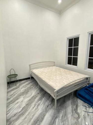 a white room with a bed and a table at Laura villa in Cisarua