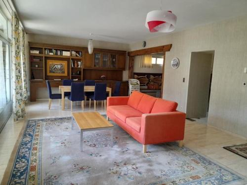 a living room with a red couch and a table at Apartment Pavillon Castagneto by Interhome in Castasegna