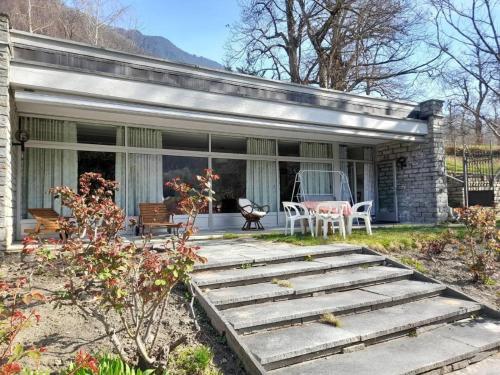 a home with a patio with a table and chairs at Apartment Pavillon Castagneto by Interhome in Castasegna