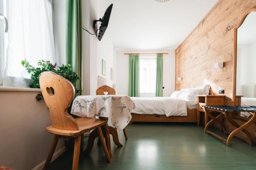 a bedroom with a bed and a table and chairs at Hotel Oasi in Cortina dʼAmpezzo