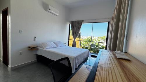 a bedroom with a bed and a large window at Chalés da Bica - Modernidade e Aconchego a 100m da Praia in Paracuru