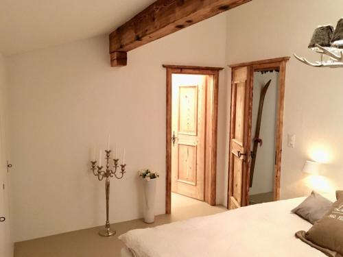 a bedroom with a bed and an open door at Apartment Alpenchic SpycherHus by Interhome in Klosters