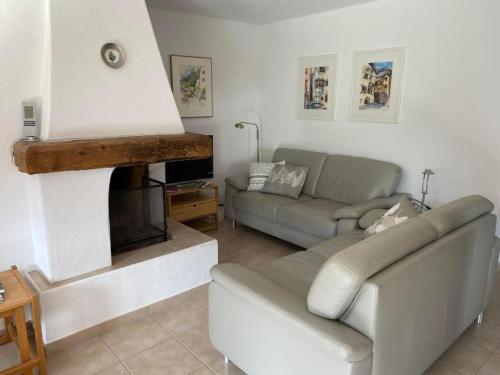 a living room with a couch and a fireplace at Apartment Chesa Engel by Interhome in La Punt-Chamues-ch