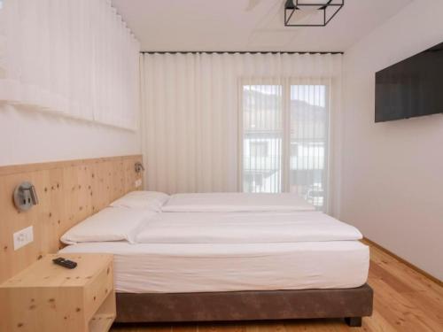 a bedroom with a large bed and a large window at Apartment Duai by Interhome in Müstair