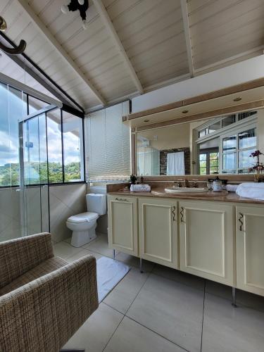 a bathroom with a toilet and a sink and a mirror at Pousada Casa Thede in São Salvador