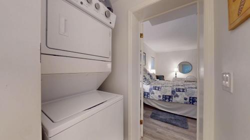 a small kitchen with a refrigerator and a bedroom at Atlantic Breeze #4 in Jekyll Island