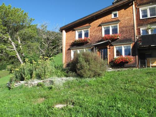a brick house with flowers in front of it at Apartment Gubel by Interhome in Alt Sankt Johann