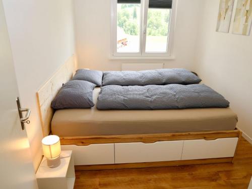a bed in a room with a window at Apartment Panoramablick by Interhome in Nesslau