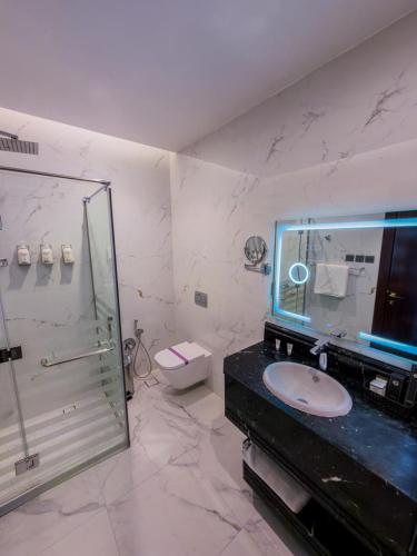 a bathroom with a glass shower and a sink at فندق ترى النزهة -Tura Hotel AlNuzha in Riyadh