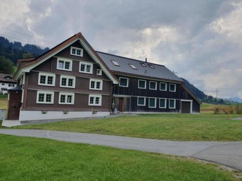 a large brown house with a gambrel roof at Apartment Bädli by Interhome in Wildhaus