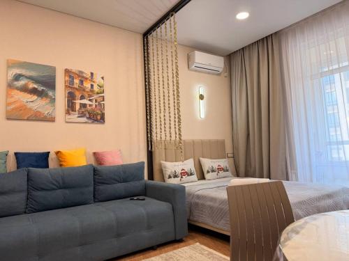 a living room with a couch and a bed at ЖК Tandau 399 in Almaty