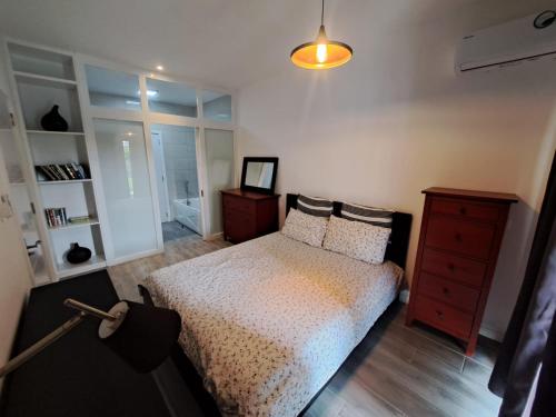 a bedroom with a bed and a dresser and a lamp at The Heritage Roches Noires in Roches Noires