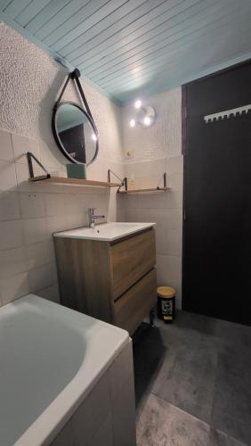 a bathroom with a sink and a mirror at Coeur de Koss Climatisé in Blars