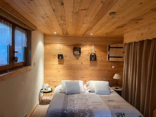 a bedroom with a bed with a wooden ceiling at LA VARNACHE logement cosy in Bonvillard