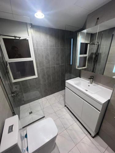a bathroom with a white toilet and a sink at Nasma Homes Al Dana in Abu Dhabi