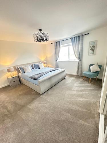 a white bedroom with a bed and a chandelier at Perceval Road, Stornoway Town in Stornoway