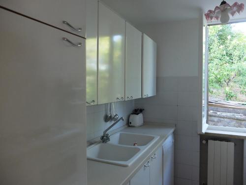 a white kitchen with a sink and a window at Bellevue, country house in Velletri
