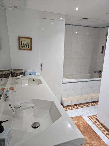 Gîte Noa في كسونبورت-لونجمير: حمام أبيض اللون مزود بحوض استحمام ومرحاض