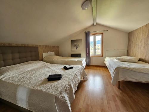 Gîte Noa في كسونبورت-لونجمير: غرفة فندق بها سريران ونافذة