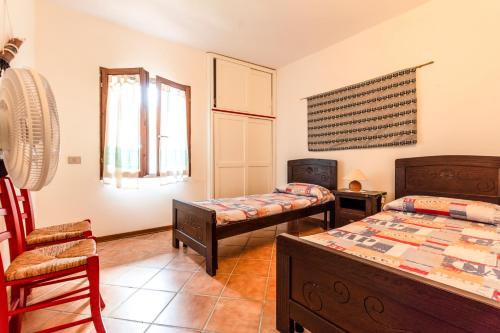 a bedroom with two beds and a chair at Asfodeli Holiday Home in Monte Nai