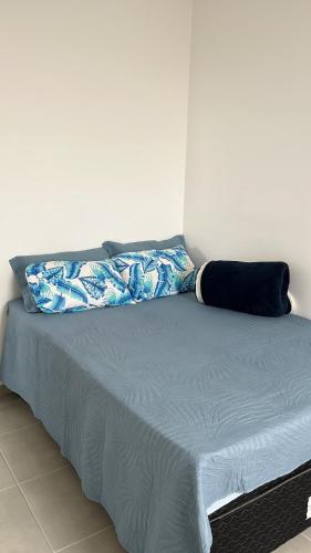 a bed with two pillows on top of it at Doce lar in Pouso Alegre