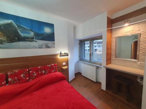 a bedroom with a red bed and a tv at Il RIFUGIO DELLO SCIATORE RESIDENCE PARADISO in Roccaraso
