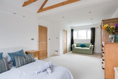 a bedroom with a bed and a couch at Harbourways Emsworth, Pet Friendly Coastal Retreat, Contractors & Leisure, Free Parking, Walk to Pubs in Emsworth