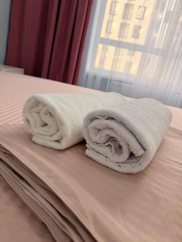 two towels sitting on top of a bed at ЖК Tandau 399 in Almaty