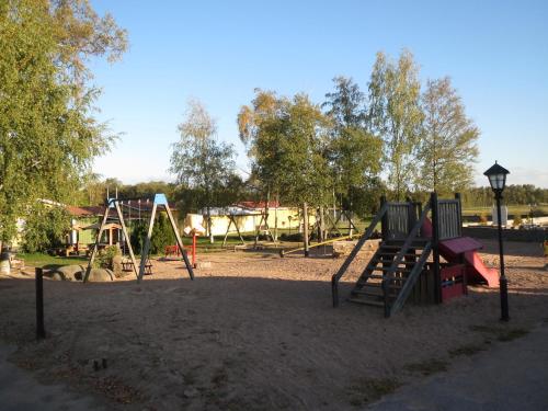 un parque con parque infantil con columpios en Björkbackens Stugby i Vimmerby, en Vimmerby