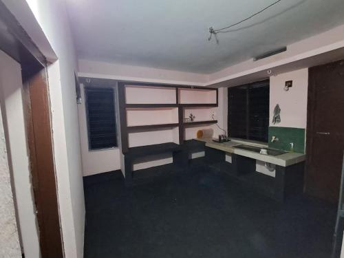 a kitchen with a counter and a sink and windows at A-Kutty in Irinjālakuda