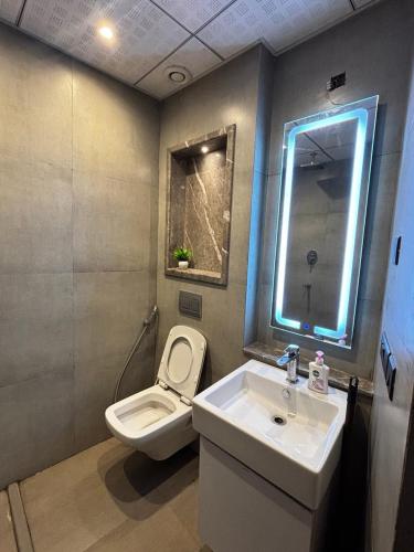 a bathroom with a sink and a toilet and a mirror at Supernova spira in Noida