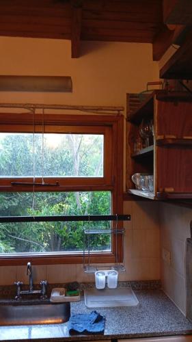 a kitchen with a sink and a window at Casa con pileta, Mar Azul in Mar Azul