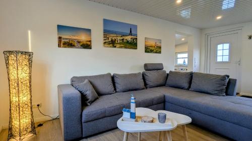 a living room with a blue couch and a table at Ferienwohnung Dennis in Nordleda
