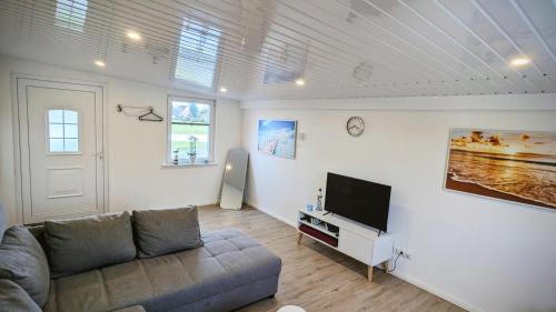 a living room with a couch and a flat screen tv at Ferienwohnung Dennis in Nordleda