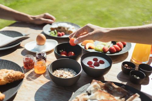 a table with plates of food and bowls of food at Gailerhof Boutique Hotel B&B Dolomites in Monguelfo